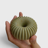JONES + CO lülala hand-crafted soap bar in sage green with a ribbed, geometric donut shape held in a palm.