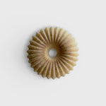 JONES + CO lülala vetiver and makrut lime soap bar with a circular, fluted design and natural clay texture.