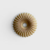 JONES + CO lülala vetiver and makrut lime soap bar with a circular, fluted design and natural clay texture.