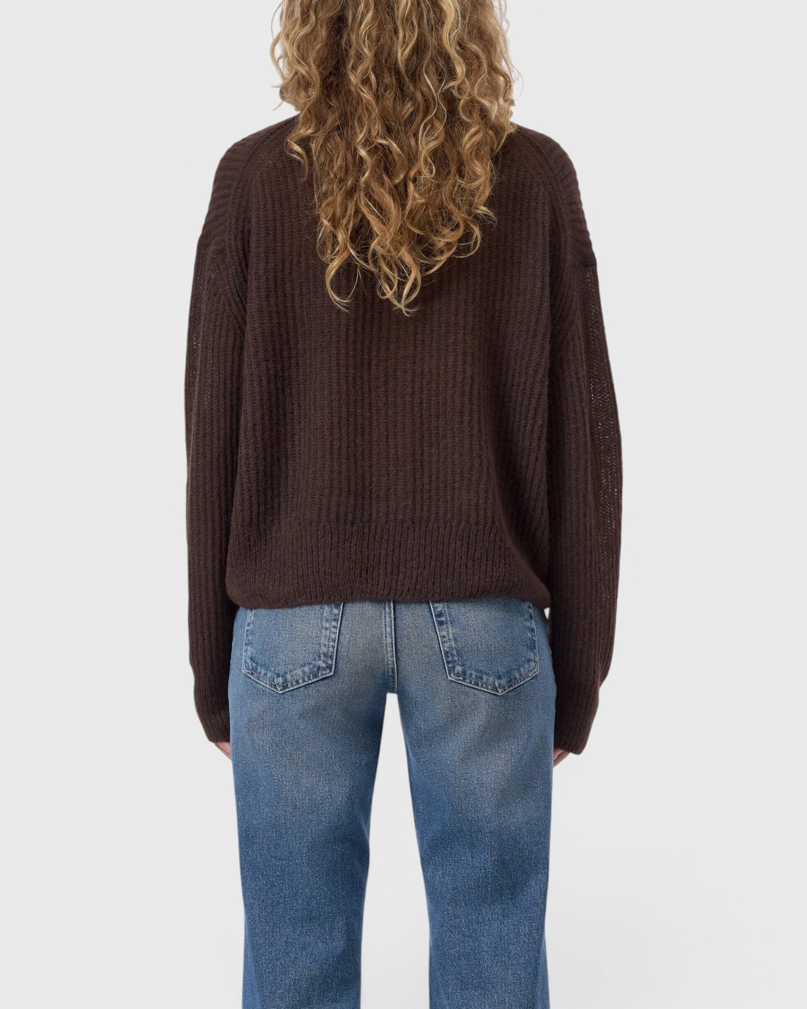 JONES + CO mahogany brown alpaca-blend V-neck cardigan worn with blue jeans, back view showing ribbed knit texture.