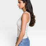 JONES + CO Maria V Neck tank top in sugar white ribbed fabric with a v-neckline, worn by a model with dark hair.