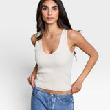 JONES + CO Maria V Neck tank top in sugar white ribbed fabric with a v-neckline. Model wears blue jeans.