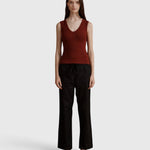 Model wearing JONES + CO merlot ribbed knit Kana Tank with deep scoop neckline and fluid fit against grey background