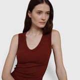 Model wearing a JONES + CO Kana Tank in merlot, featuring a deep scoop neckline and finely ribbed knit fabric.