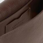 JONES + CO Mezzo crossbody bag in chaga brown textured leather with brass hardware and interior card pocket.
