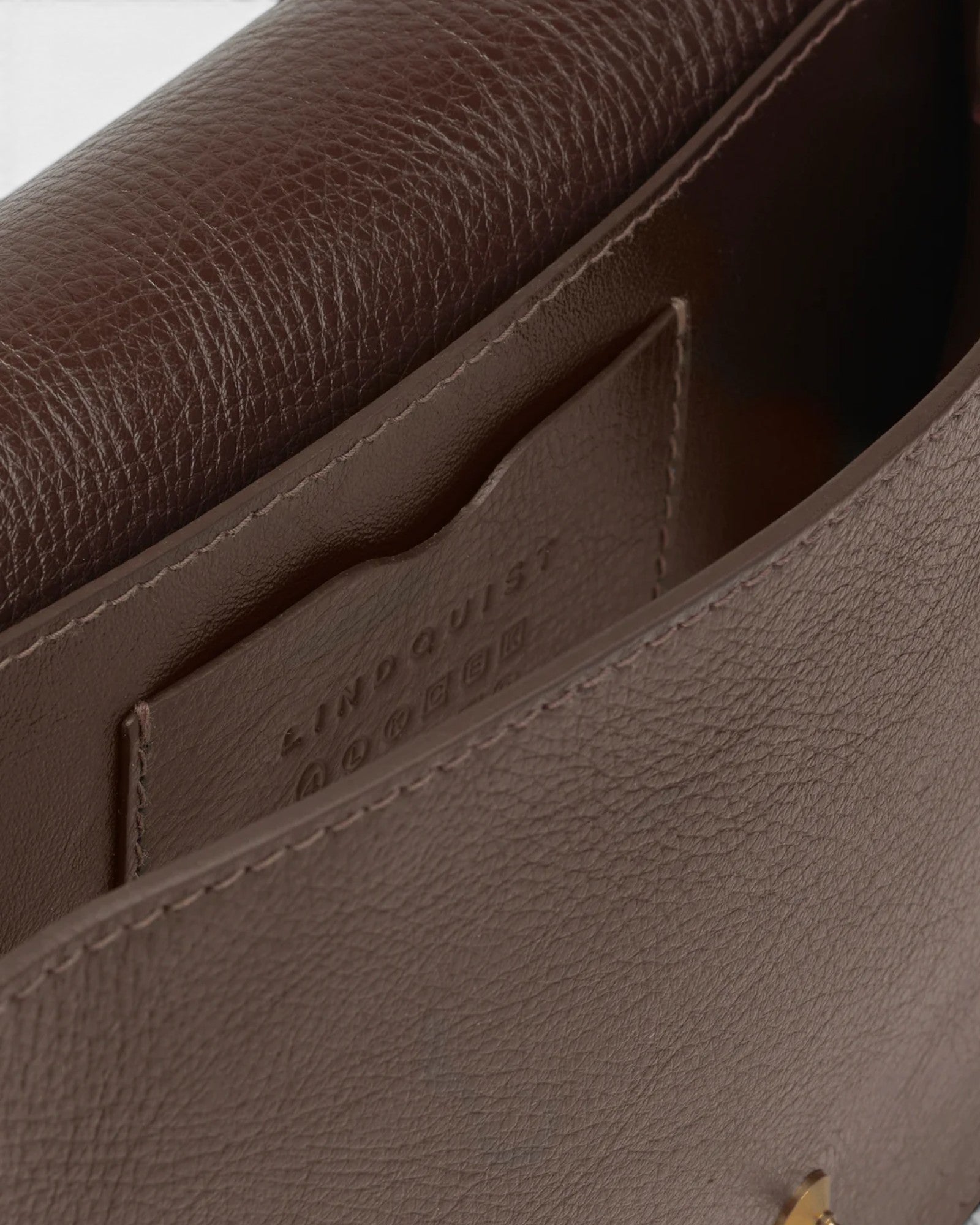 JONES + CO Mezzo crossbody bag in chaga brown textured leather with brass hardware and interior card pocket.