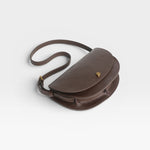 JONES + CO Mezzo crossbody bag in dark brown textured leather with brass hardware and adjustable strap.