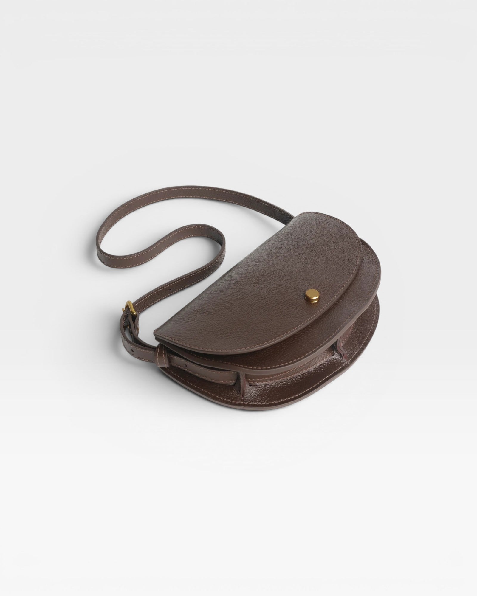 JONES + CO Mezzo crossbody bag in dark brown textured leather with brass hardware and adjustable strap.