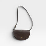 JONES + CO Mezzo crossbody bag in dark brown pebbled leather with brass hardware and adjustable strap.