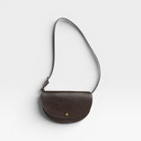 JONES + CO Mezzo crossbody bag in dark brown pebbled leather with brass hardware and adjustable strap.