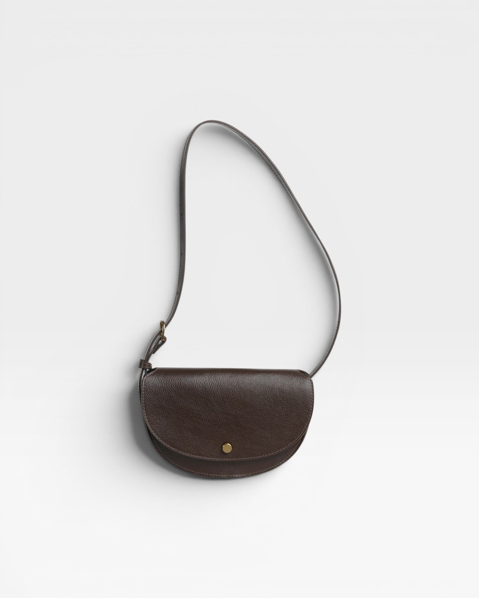JONES + CO Mezzo crossbody bag in dark brown pebbled leather with brass hardware and adjustable strap.