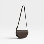 JONES + CO Mezzo crossbody bag in dark brown textured leather with brass hardware and adjustable strap.