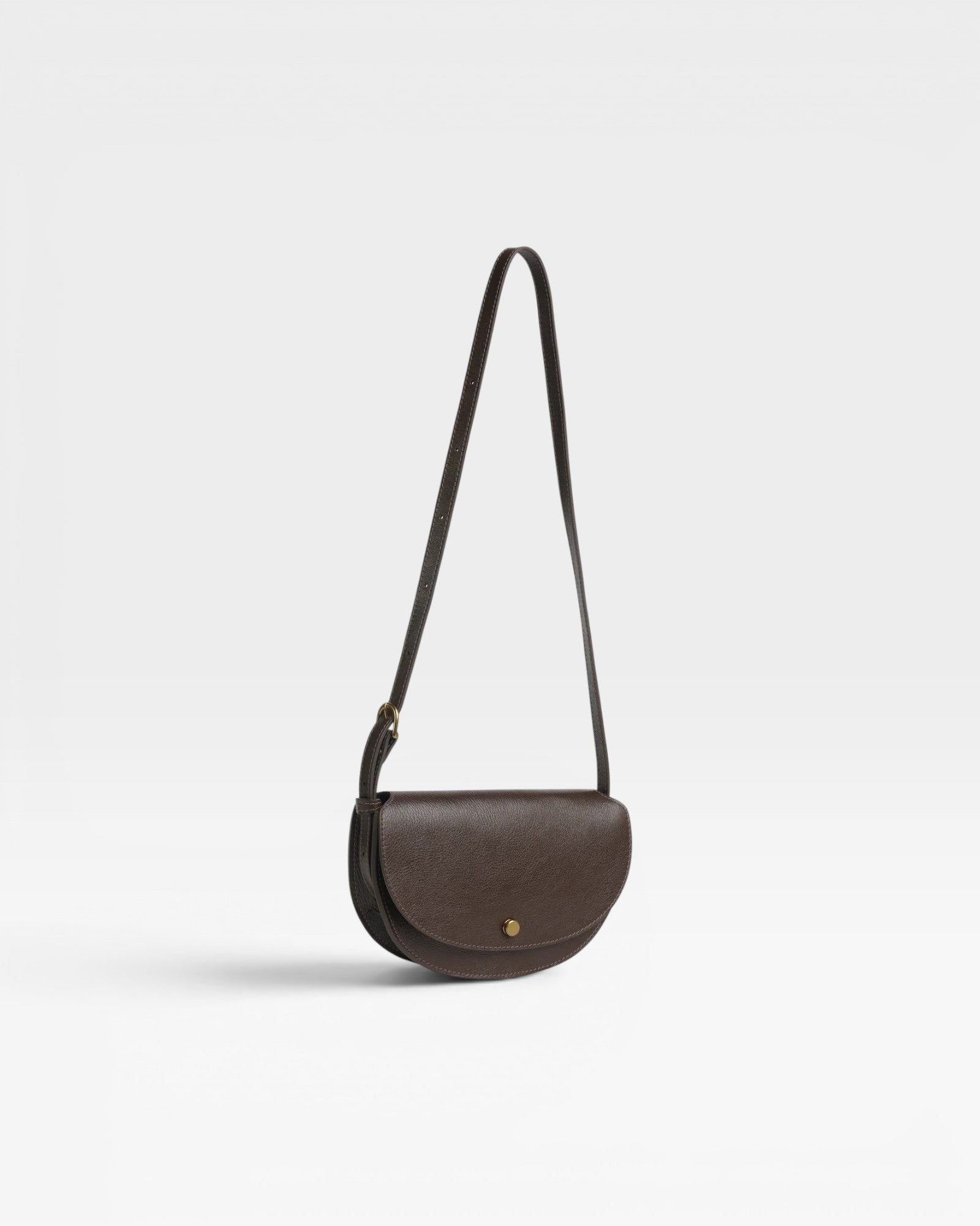 JONES + CO Mezzo crossbody bag in dark brown textured leather with brass hardware and adjustable strap.