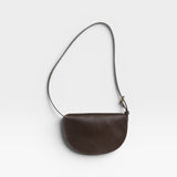 JONES + CO Mezzo crossbody bag in dark brown pebbled leather with brass hardware and adjustable strap.