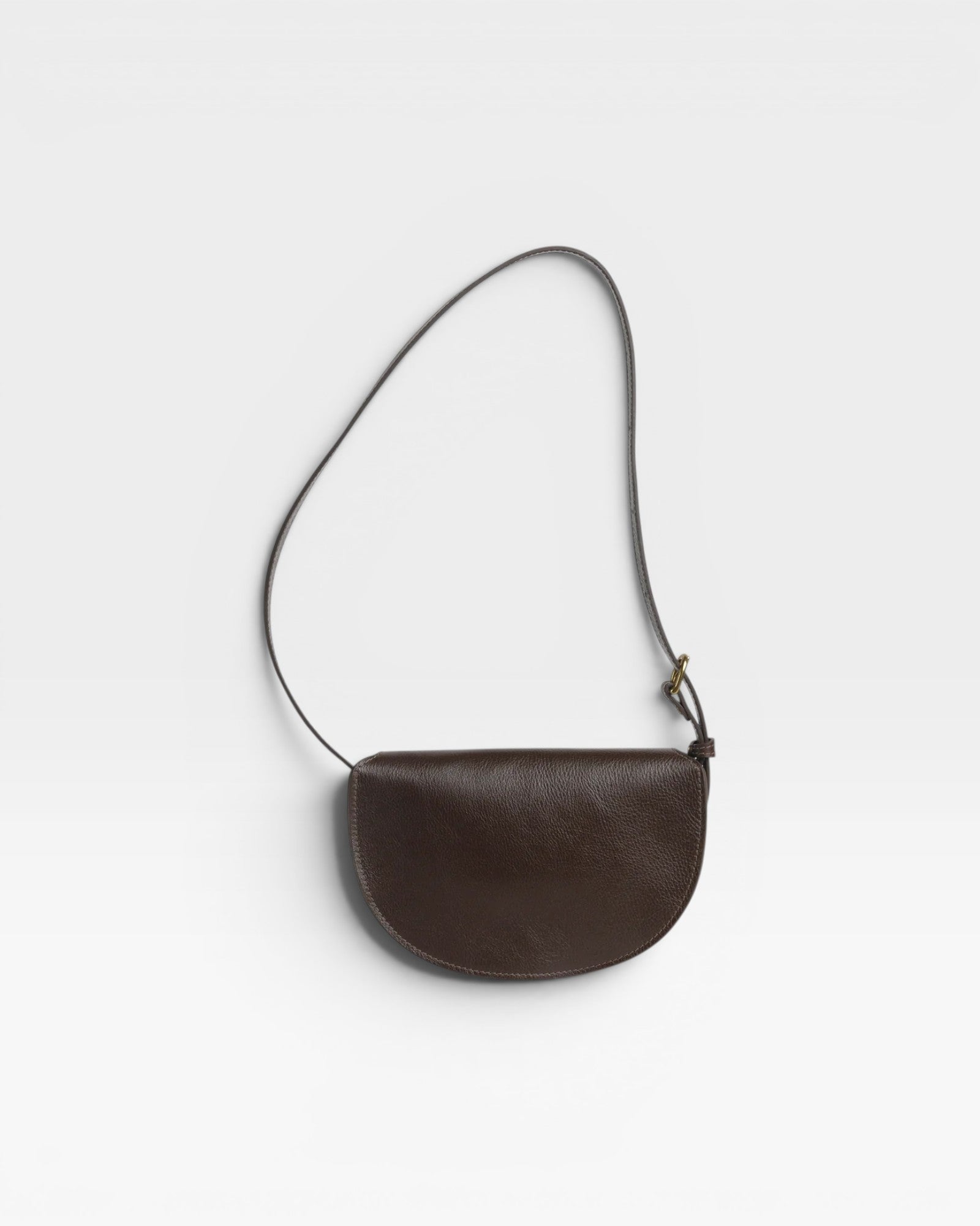 JONES + CO Mezzo crossbody bag in dark brown pebbled leather with brass hardware and adjustable strap.
