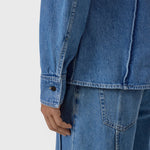 JONES + CO mid blue denim shirt featuring curved seam detailing and buttoned cuffs in a fitted silhouette.