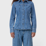 JONES + CO mid-blue denim shirt with curved seams, pointed collar, and button-front closure on a model.