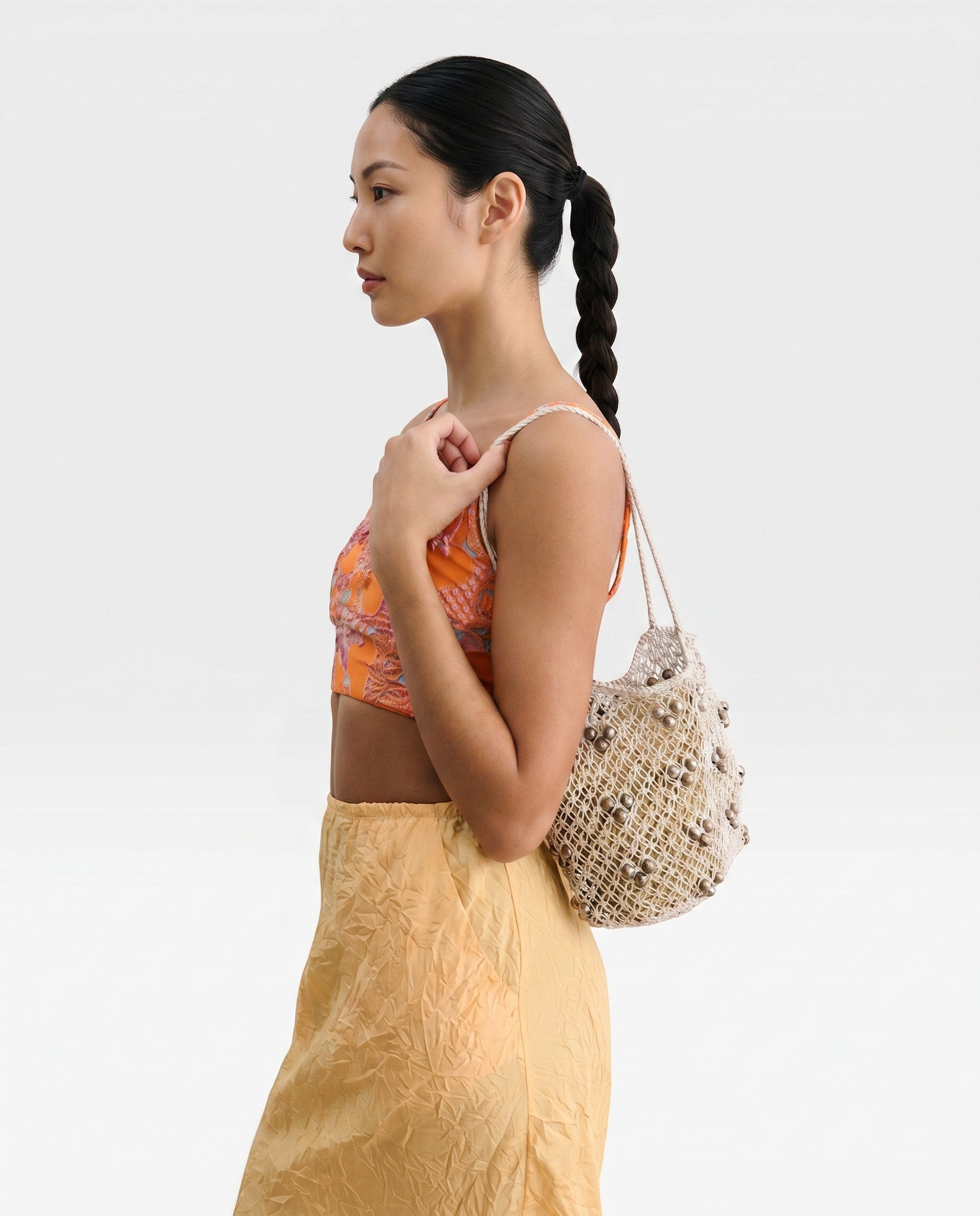 JONES + CO Mini Web Bag in silver, crafted from macrame leather beads. Sculptural yet slouchy shoulder bag.