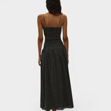 Back view of JONES + CO Mira maxi dress in black with off-white polka dots, featuring spaghetti straps and smocking.