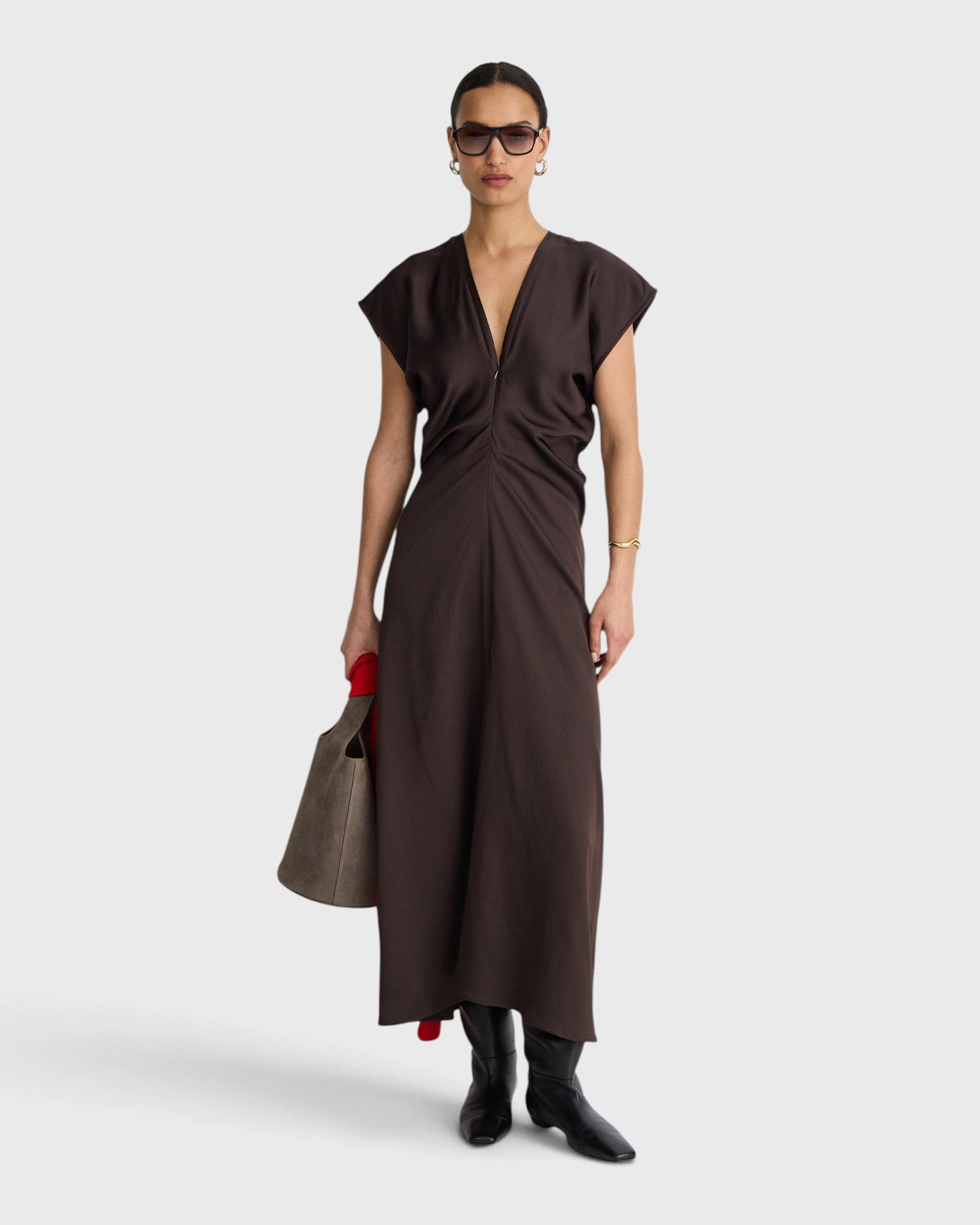 JONES + CO  apiece apart Monde black coffee bias-cut maxi dress with V-neck, front zip, and draped silhouette on a model.