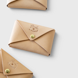 JONES + CO natural vegetable-tanned cowhide card case with brass snap closure and embossed logo.