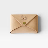 JONES + CO natural vegetable-tanned cowhide Sovana card case with envelope closure and brass snap button.