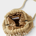 JONES + CO natural raffia crochet mini clutch with shell embellishments and gold satin lining. Features a chain strap.