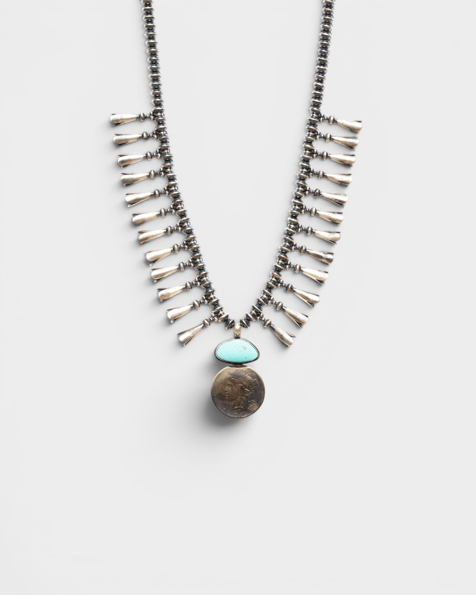 JONES + CO Navajo Squash Blossom Necklace with sterling silver, turquoise, and a 1921 US dollar coin.