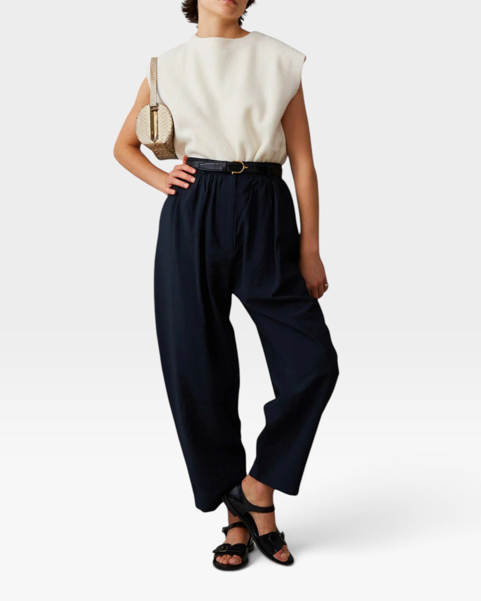 JONES + CO navy Brady trousers with a high-waisted, gathered design and tapered cropped leg on a model.