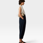 Model wearing JONES + CO navy Brady trousers with a high-waisted, tapered, cropped fit and side pockets.