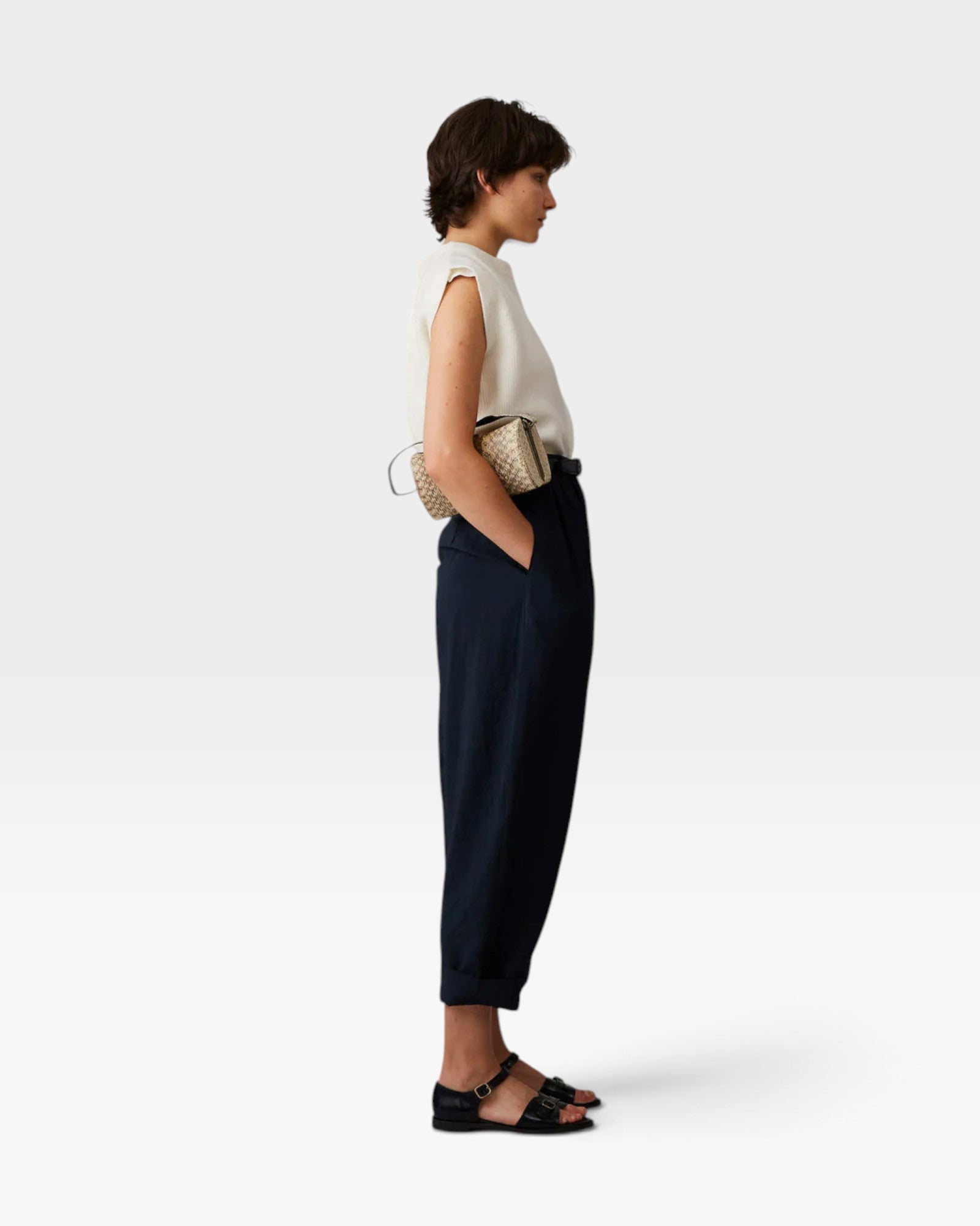 Model wearing JONES + CO navy Brady trousers with a high-waisted, tapered, cropped fit and side pockets.