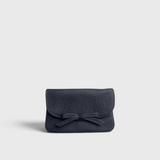 JONES + CO navy blue pebbled leather petite case with a decorative knotted bow and hidden magnetic closure