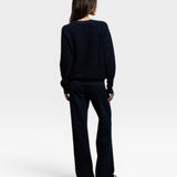 Woman wearing a navy JONES + CO Ziggy sweatshirt and matching trousers, viewed from the back.