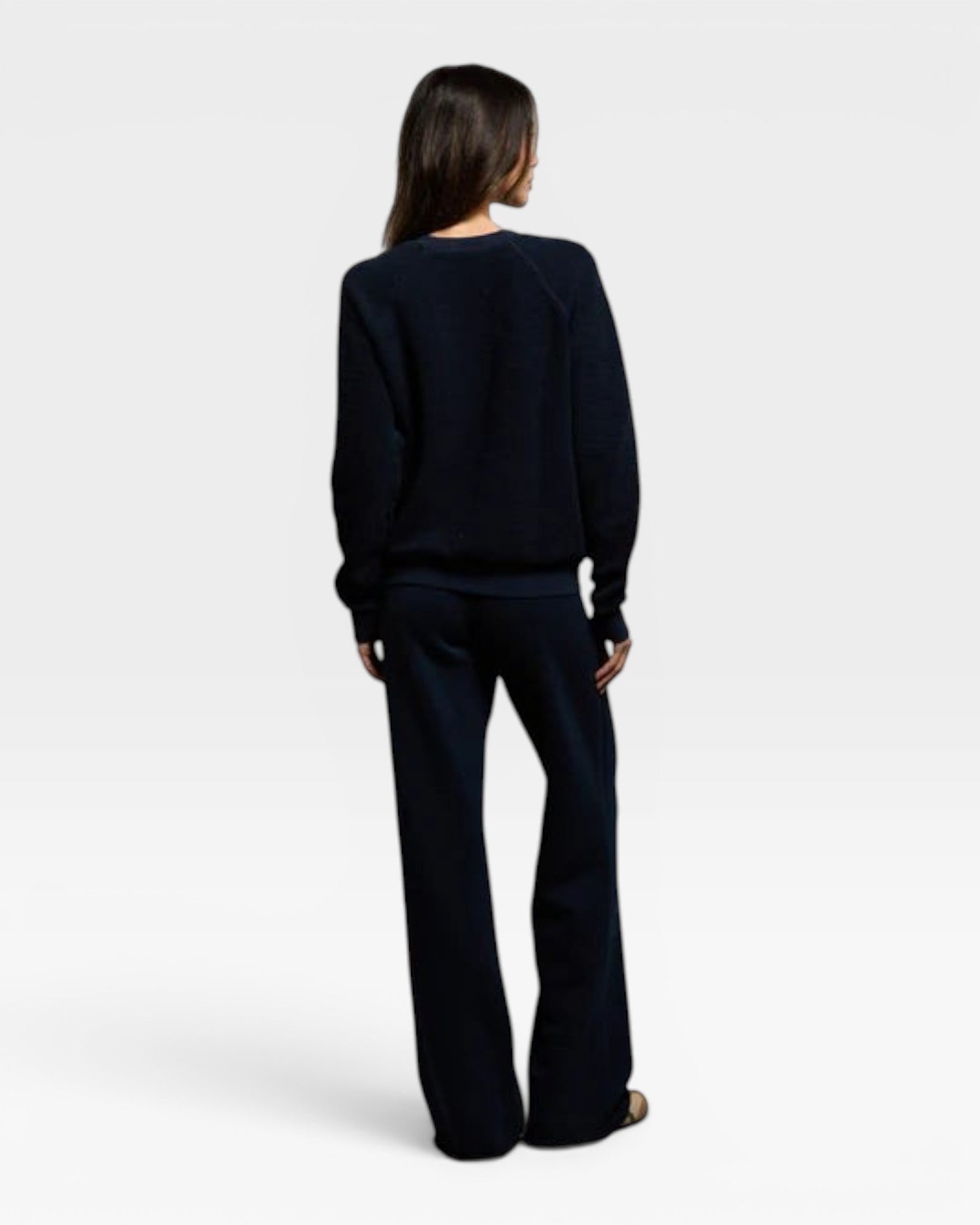 Woman wearing a navy JONES + CO Ziggy sweatshirt and matching trousers, viewed from the back.