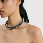 JONES + CO Nerium Necklace with rhinestones, seed beads, and floral beads in blue, green, and pink. Tubular roll shape with adjustable chain.