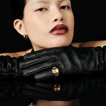 JONES + CO Nocturne Time Ring in 18K gold-plated stainless steel with amber crystal on a model wearing black gloves.