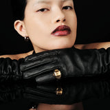 JONES + CO Nocturne Time Ring in 18K gold-plated stainless steel with amber crystal on a model wearing black gloves.