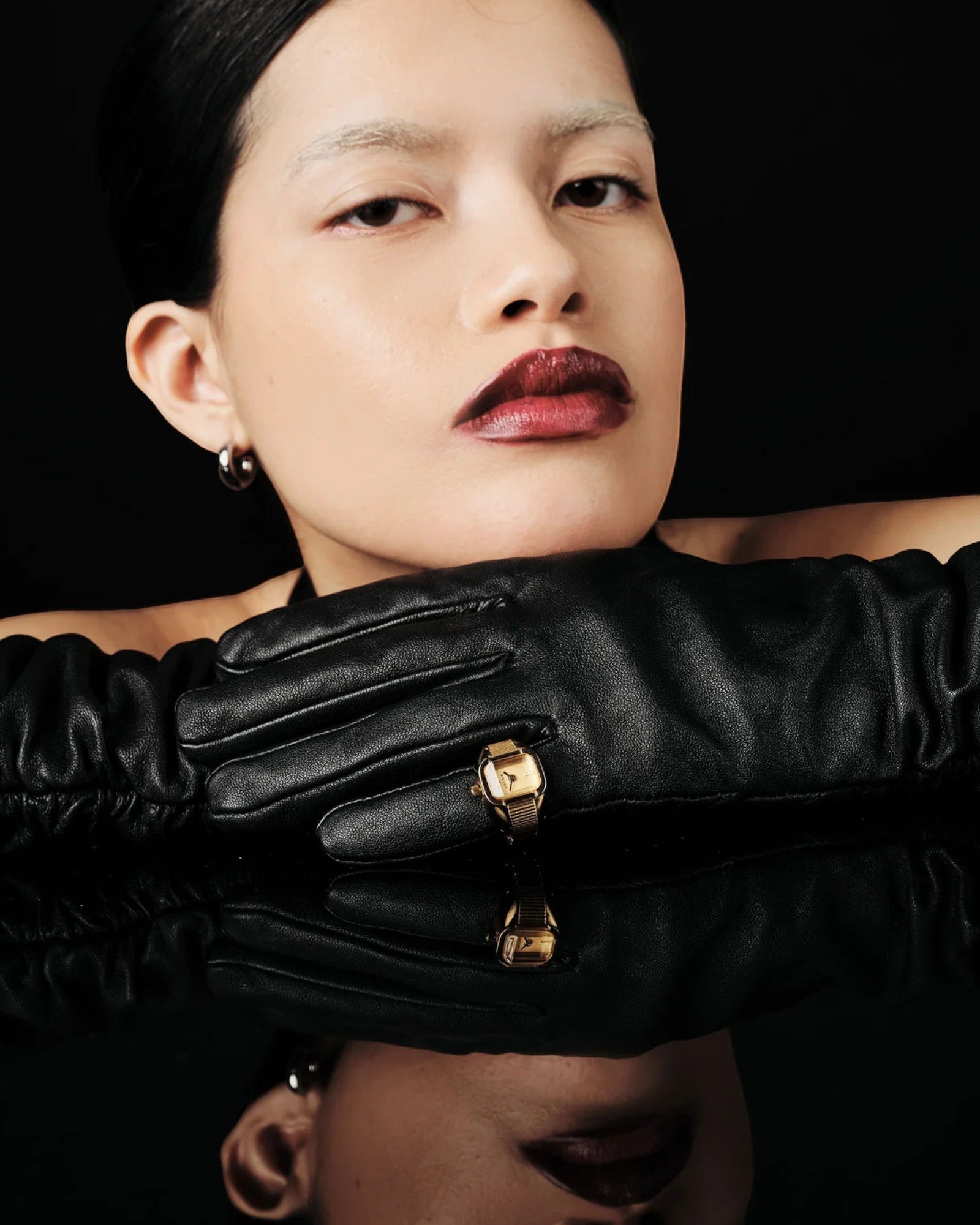 JONES + CO Nocturne Time Ring in 18K gold-plated stainless steel with amber crystal on a model wearing black gloves.