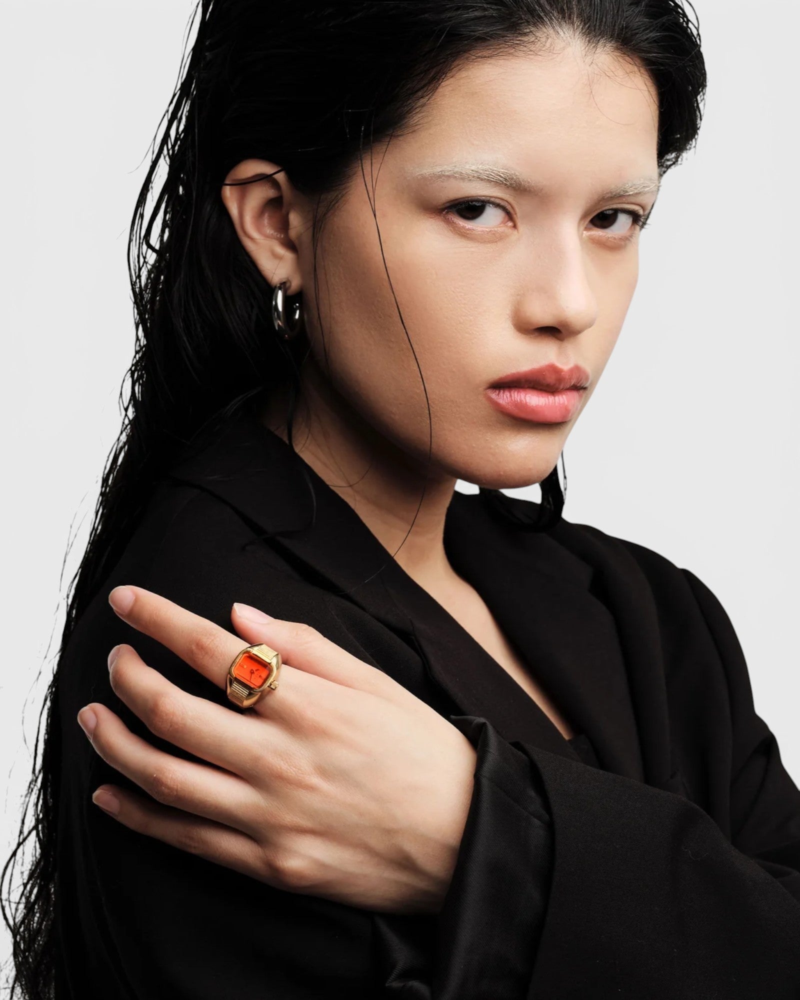 JONES + CO Nocturne Time Ring in 18K deep gold-plated stainless steel with a flame-colored crystal on a model's hand.