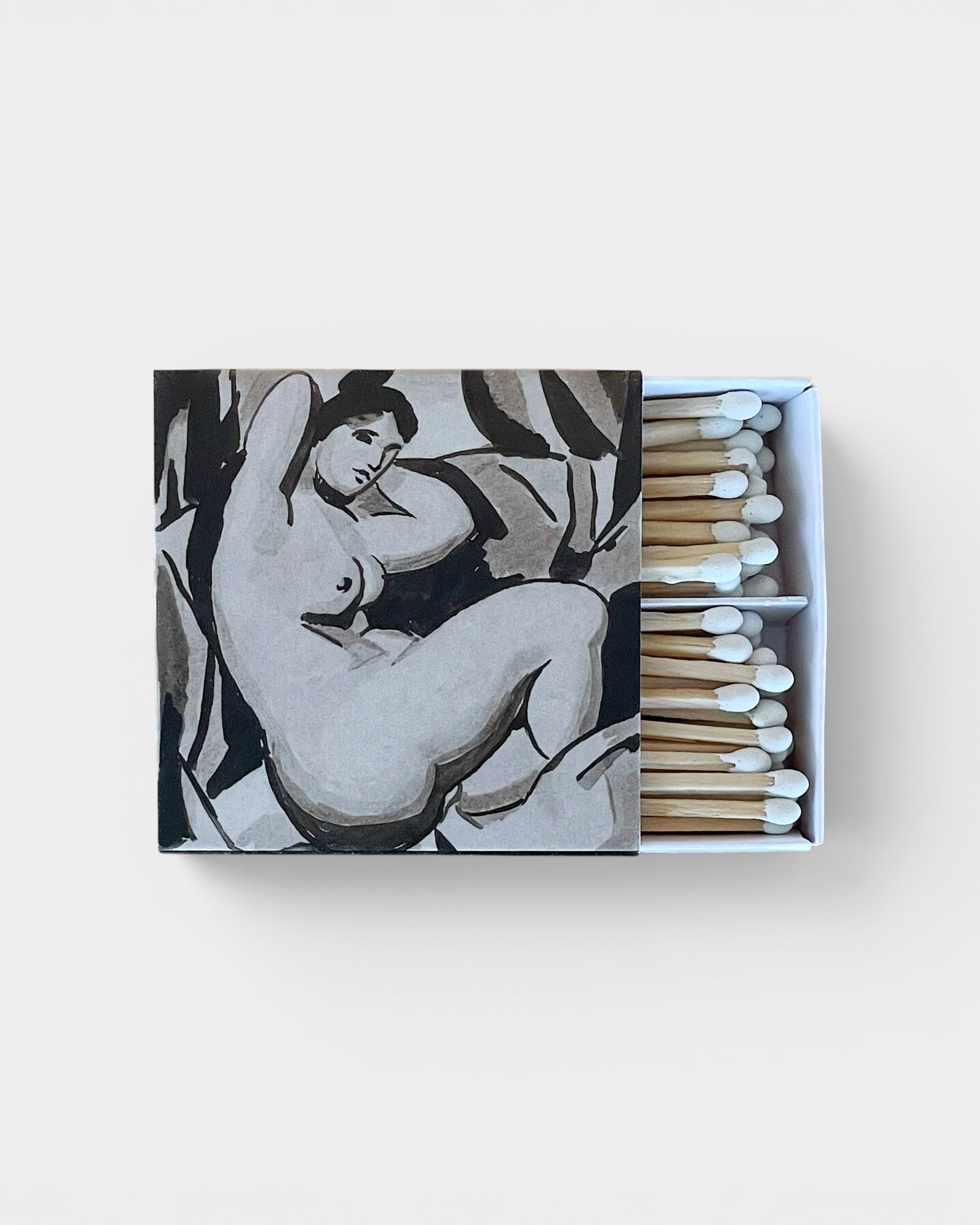 JONES + CO Nue matchbox featuring a black and white artistic nude illustration with white-tipped wooden matches.