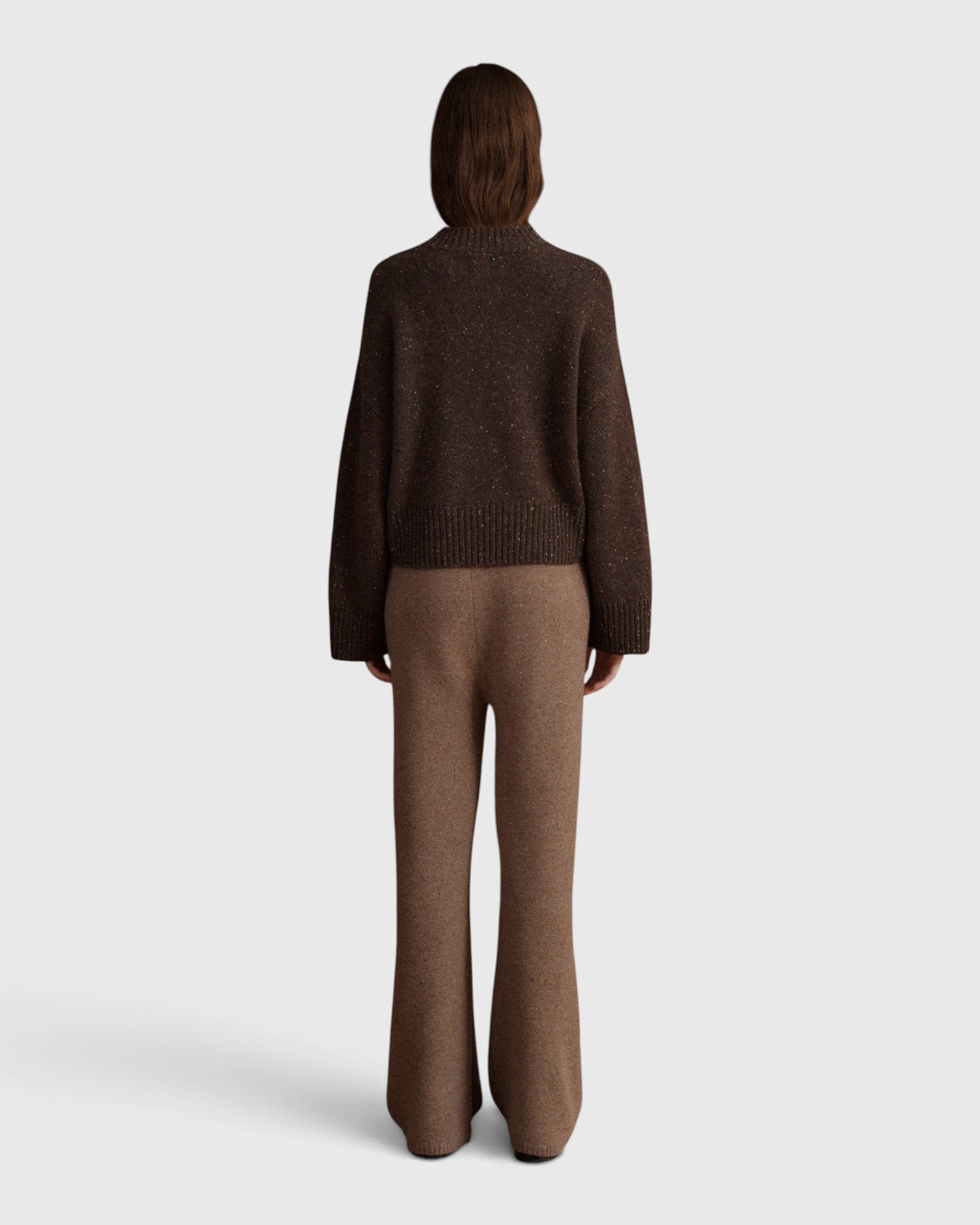 Back view of a model wearing a JONES + CO oak brown cashmere mock-neck sweater with balloon sleeves and matching pants