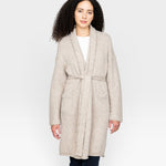 JONES + CO oatmeal alpaca wool blend sweater coat with belt and pockets, worn by a woman with curly hair.