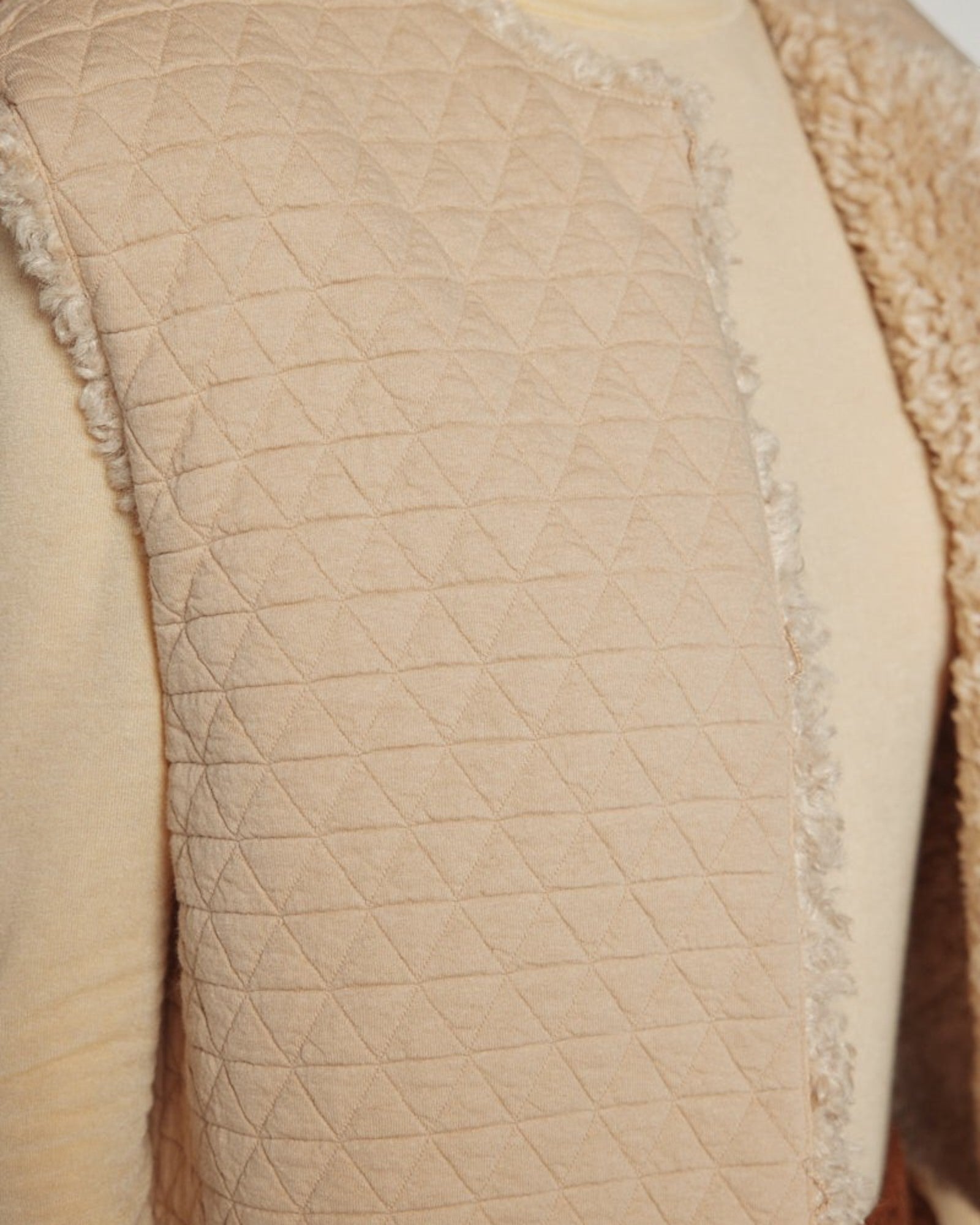 JONES + CO oatmeal reversible vest featuring a quilted texture on one side and plush faux fur trim detail.