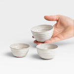 JONES + CO handcrafted off-white ceramic little bowls with ribbed texture held in a hand