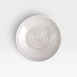 JONES + CO off-white ceramic garlic grater plate with a circular ridged center for grating garlic and herbs.