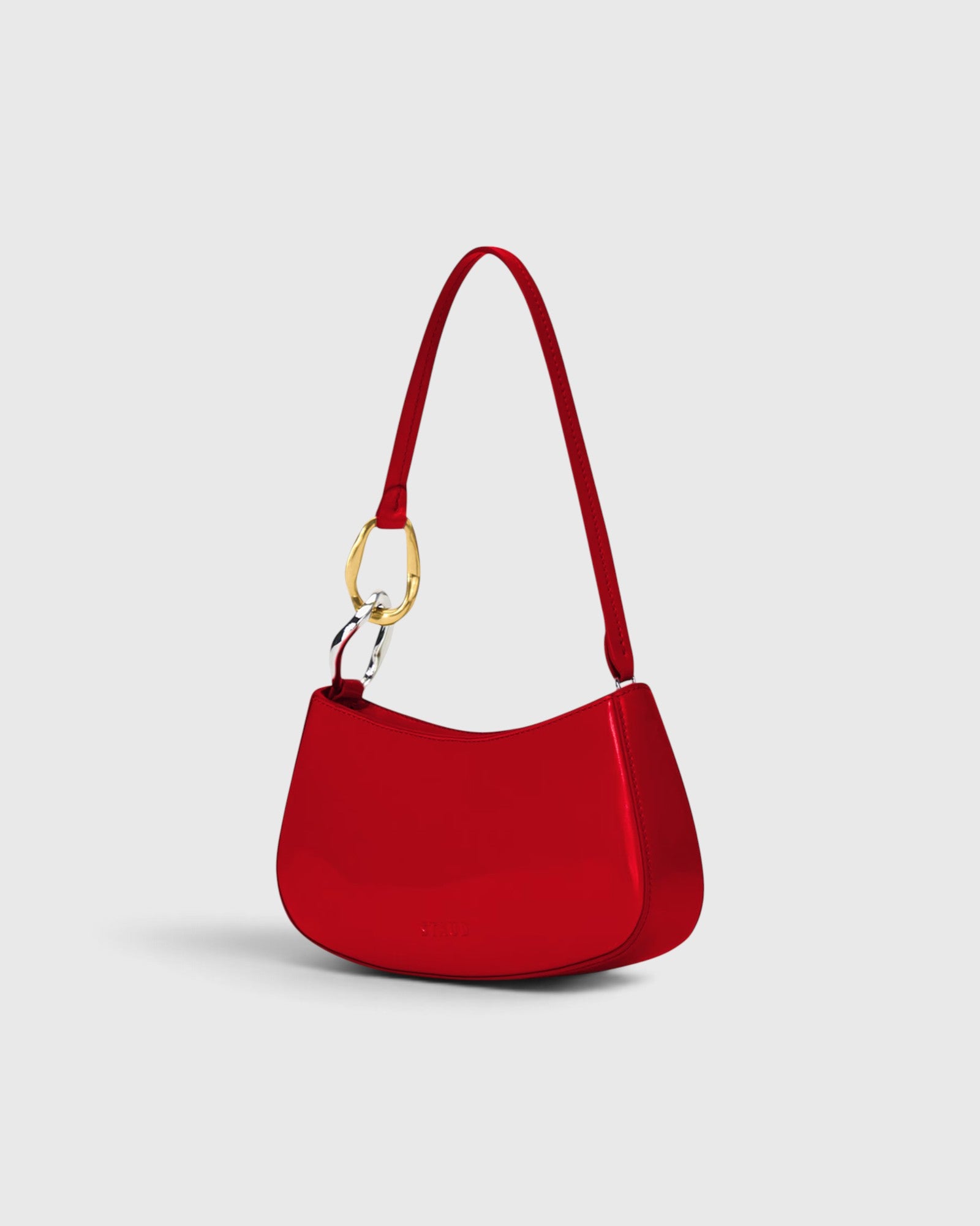 JONES + CO Ollie Bag in polished cherry-red leather with a crescent shape, shoulder strap, and gold-tone hardware.
