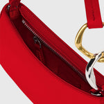JONES + CO Ollie Bag in cherry red polished leather with a crescent shape, gold hardware, and secure zip closure.