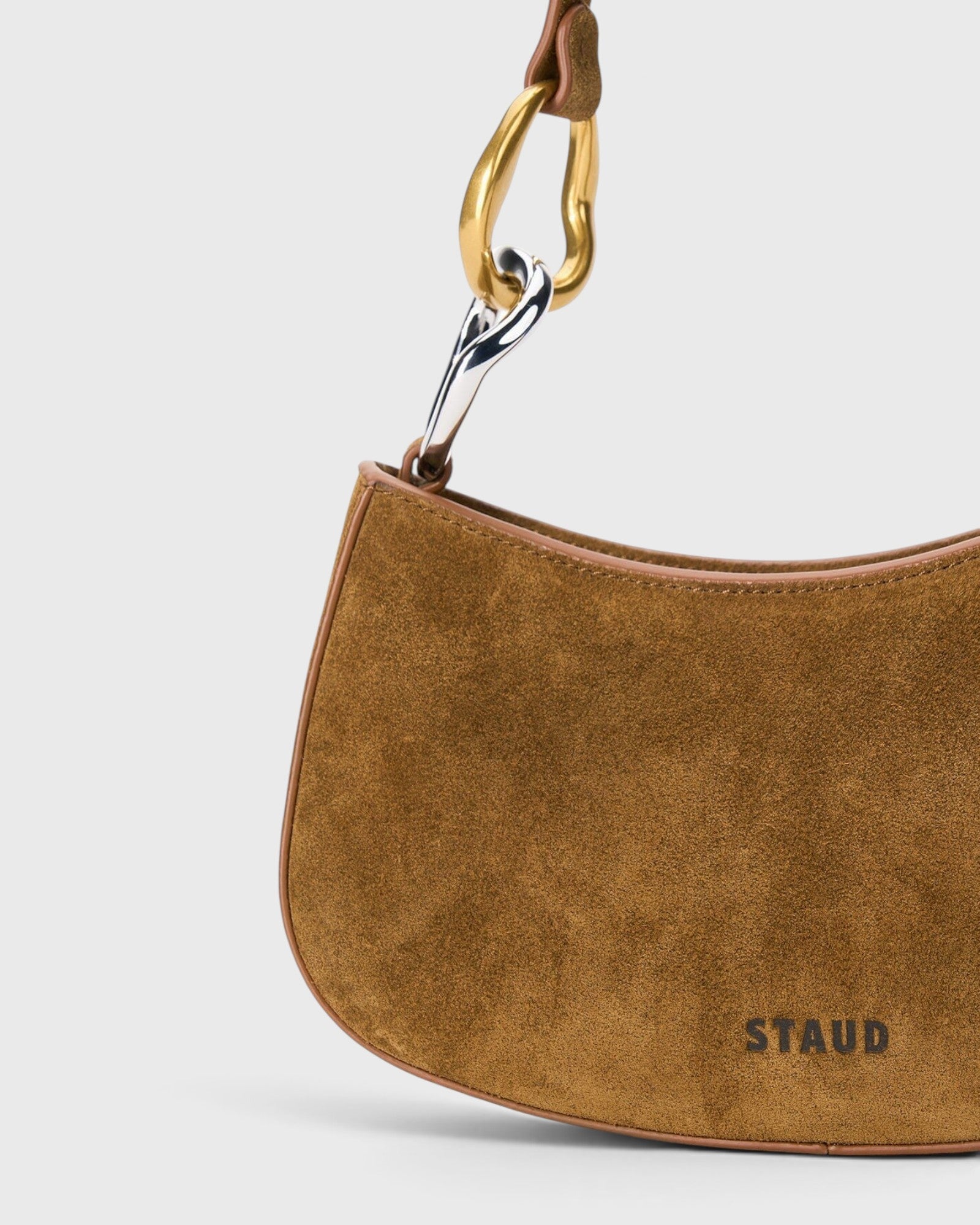 JONES + CO Ollie Bag in cigar tobacco suede with a curved crescent shape and two-tone gold and silver link strap.