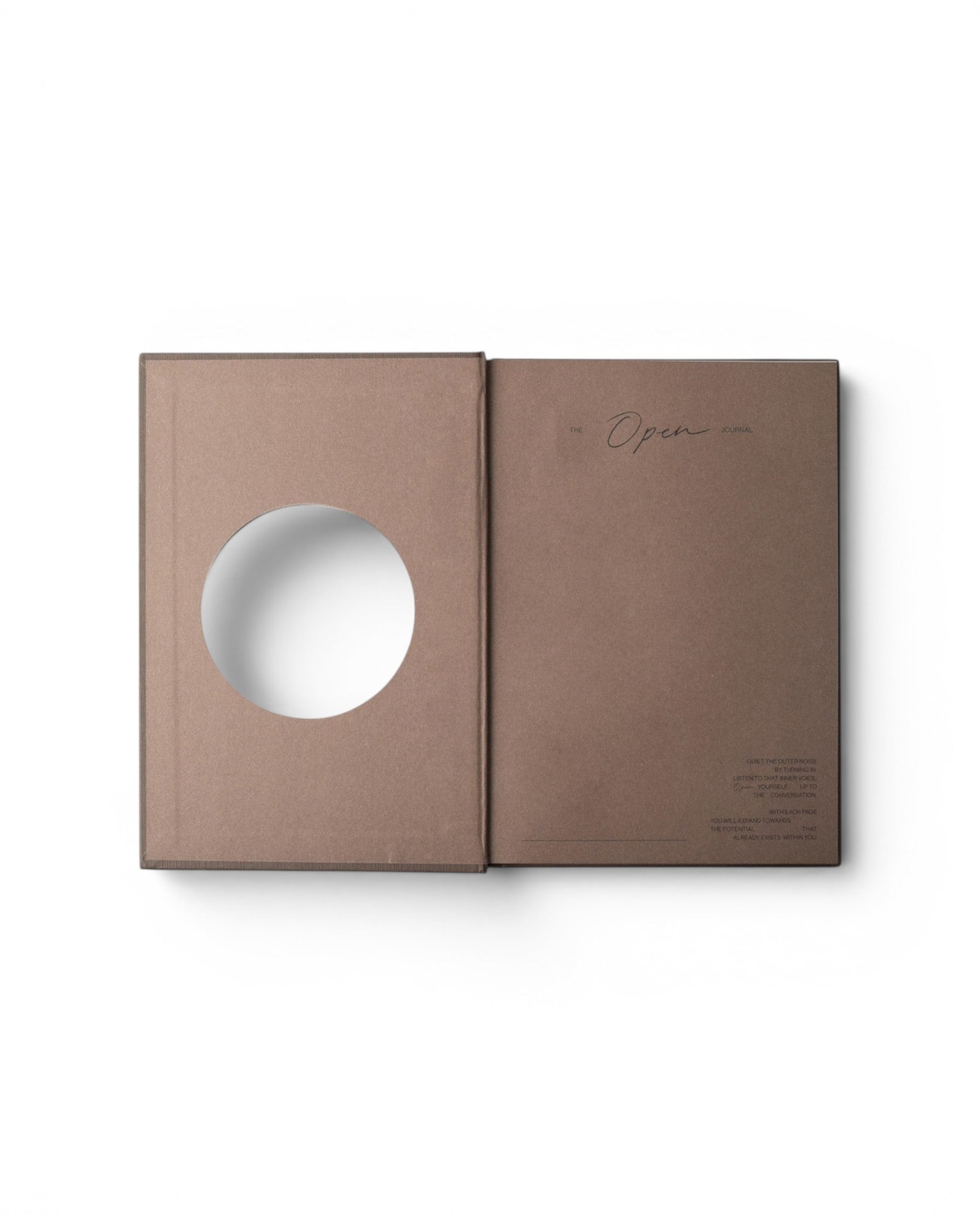 JONES + CO Open Journal with a brown fabric cover and a circular cutout on the front page, flat lay view.