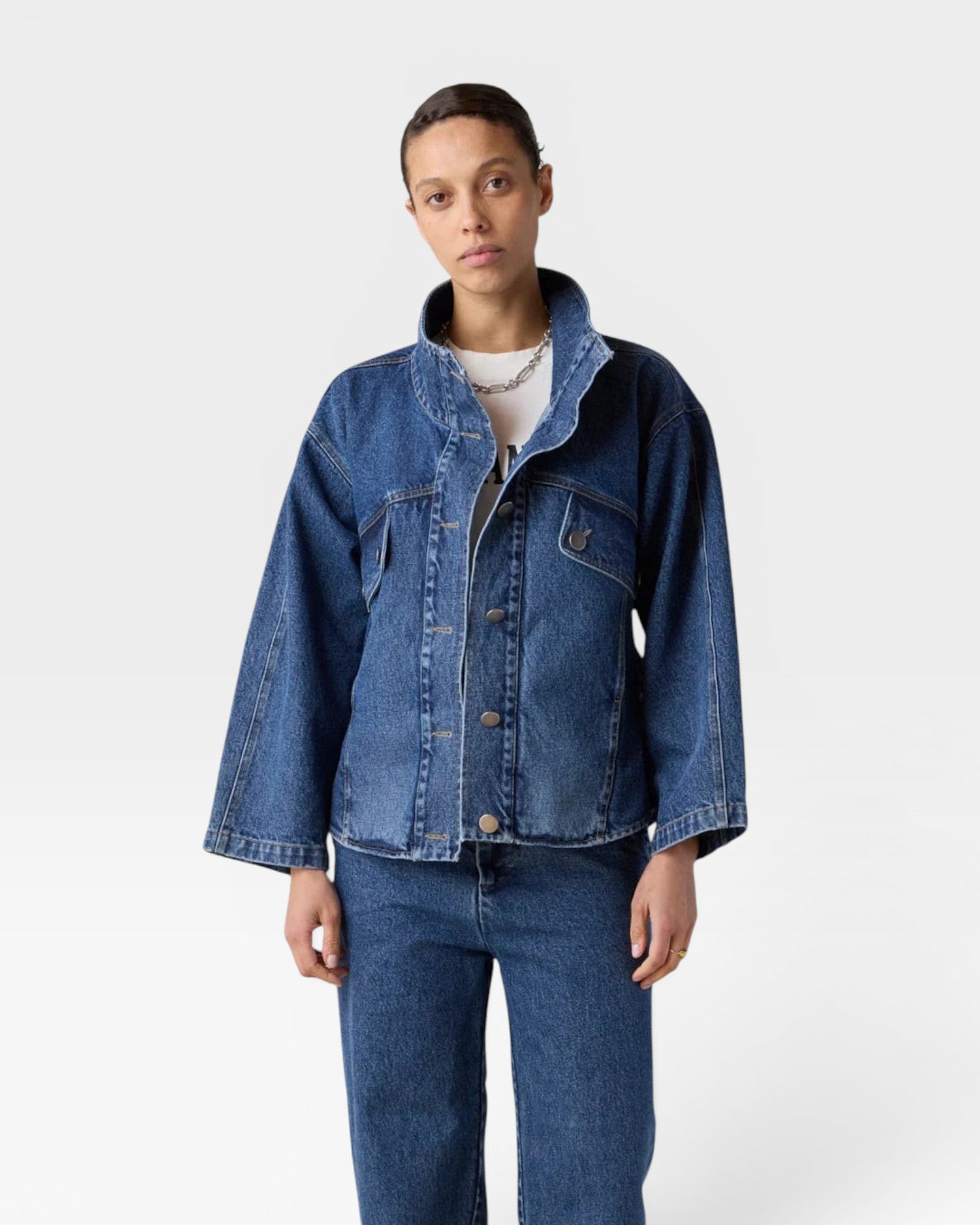 JONES + CO dark wash denim oversized jacket with stand collar, asymmetric snap closure, and flap pockets.